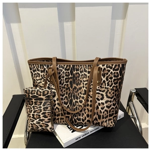 Leopard print tote bag set with matching pouch and brown PU handles on a minimalist chair