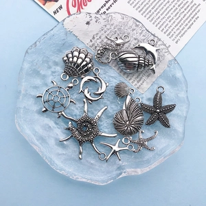 Detailed view of silver ocean-themed alloy charms displayed on a clear glass plate