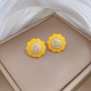 Detail of sunflower stud earrings with yellow enamel and small zircons in a gift box
