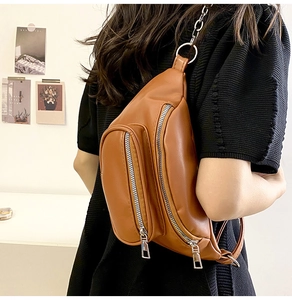 Detailed view of brown PU leather chest bag with multi-zipper pockets and chain strap