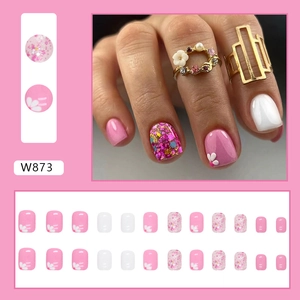 Detail of short square press-on nails with pink floral patterns and glitter finish
