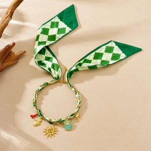 Green checkered ribbon necklace with gold charms like sun and heart charms