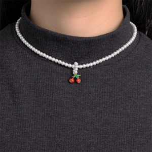 French style pearl necklace with cute red cherry pendant on a model's neck