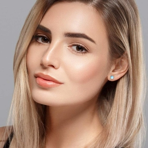 Elegant 925 silver stud earrings with round translucent blue moonstones on female model