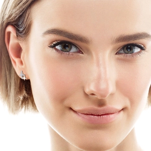 Elegant 925 sterling silver star-shaped stud earrings with sparkling moissanite on a model