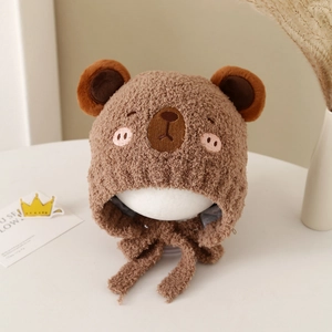 Detailed view of plush warm baby winter hat with cute bear embroidery and chin straps
