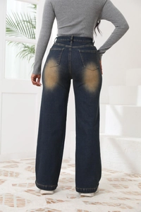 Dettaglio dei jeans a vita alta a gamba larga con lavaggio vintage sulle tasche posteriori