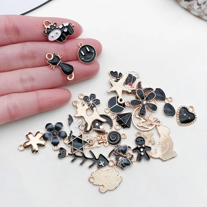 Assorted DIY enamel charms in black and gold featuring heart, star, and animal shapes