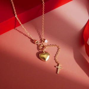 Detail der 18K vergoldeten Herz-Halskette mit Kreuzanhänger auf rotem Geschenkbox-Hintergrund