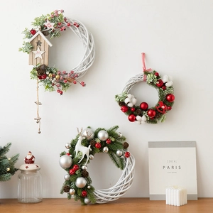 Three Nordic style white rattan Christmas wreaths with berries pinecones and reindeer