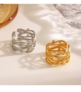 Detail of 18K gold and silver crisscross layered rings with textured dot accents