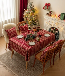 Close-up of red Christmas tablecloth with woven white reindeer and snowflake motifs