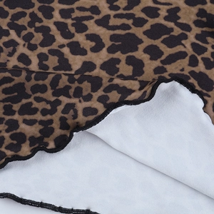Detailed close-up of leopard print fabric featuring elegant ruffled edges and quality stitching
