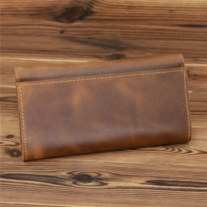 Macro detail of retro brown crazy horse leather wallet texture and precision stitching