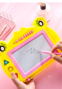 Close-up of child writing on a frog-shaped magnetic drawing board with abacus beads