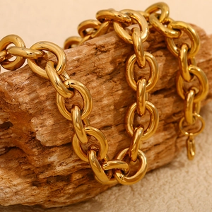 Gros plan d'un collier à grosse maille plaqué or 18 carats sur un fond en bois
