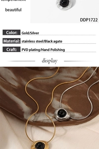 Detail of round black agate pendant with irregular gold metal frame on snake chain