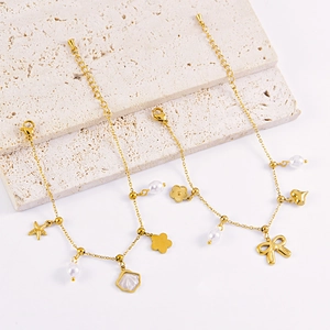Gouden armband met parels, zeesterren en schelpen op een witte stenen display