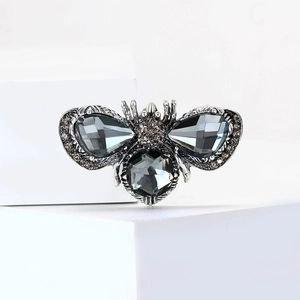 Macro shot of silver bee brooch with grey rhinestones and faceted crystal details