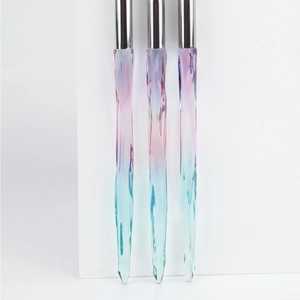 Macro detail of three eyeshadow brushes with pink and blue gradient ice-like handles