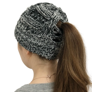 Close-up of a striped knit ponytail beanie showing the elastic back opening detail