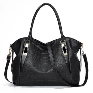 Classic black crocodile pattern handbag with gold hardware and shoulder strap on white base