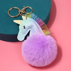 Detalle de llavero de unicornio con pompón morado, cuerno de purpurina y malla
