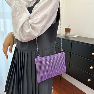 Detail of purple rhinestone shoulder bag with gold chain strap and textured finish