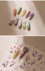 Macro detail of 3D embossed floral nail stickers and matte press-on nails with pearls