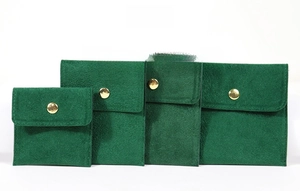 Détail de quatre tailles de pochettes bijoux en velours vert foncé avec bouton or