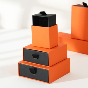 Stack of orange drawer jewelry gift boxes with black inserts in various sizes