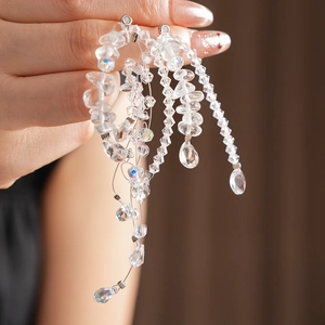 Macro shot of irregular clear crystal tassels and beaded strands on fine metal wires