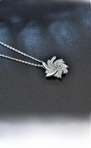 Close-up of S925 sterling silver windmill pendant necklace with sparkling moissanite stones