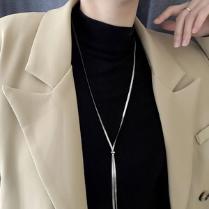 Minimalist silver snake chain long necklace with tassel pendant on a model wearing a blazer