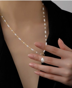 Detailed view of baroque pearl necklace with gold toggle clasp and teardrop pendant