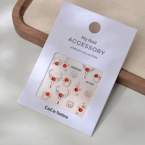 Detail of MJ-049 nail art stickers with red and white rhinestones on beige card