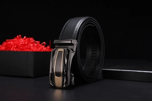 Detail of black leather belt with lychee texture and gunmetal mirror finish buckle