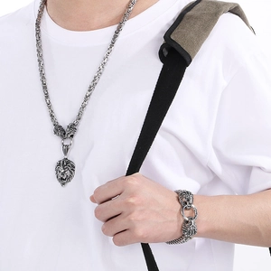 Detail view of punk lion head stainless steel necklace and bracelet set on male model