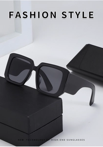 Detail view of black oversized square sunglasses on a minimalist branded packaging box