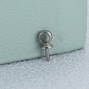 Polished silver stainless steel jewelry clasp for DIY pearl pendants on a textured surface