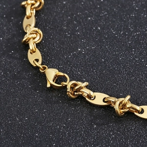 Detailed view of a gold titanium steel coffee bean chain with a secure lobster clasp