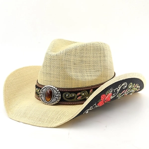 Detail of cowboy straw hat featuring floral embroidery, rhinestones and vintage gem buckle