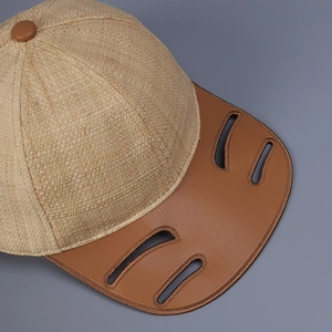 Raffia straw baseball cap with brown leather laser-cut brim and top button