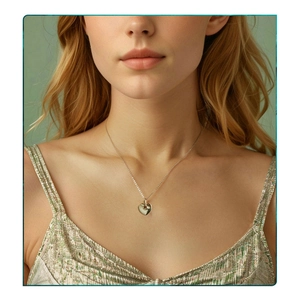 Close-up of polished S925 sterling silver heart pendant on O-chain worn by a model