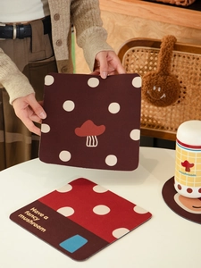 Close-up of mushroom patterned diatom mud coaster held by hand in a cozy lifestyle setting