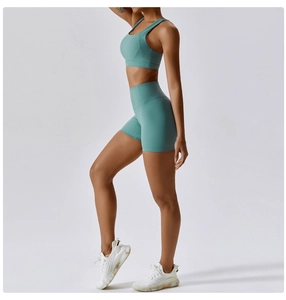 Dettaglio degli shorts da yoga a vita alta e reggiseno sportivo verde salvia in tessuto elastico