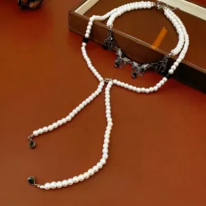 Gothic double-layered pearl necklace with dark metal wings and black teardrop pendant