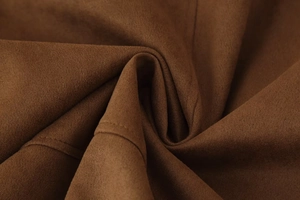 Macro detail of high-quality brown suede fabric with precise stitching on a casual jacket