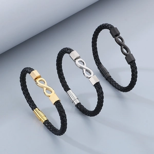 Macro detail of infinity charm on woven leather bracelets in gold, silver, and black