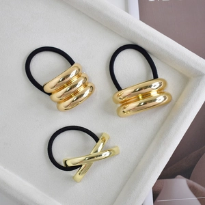 Detailed shot of three gold metal alloy hair ties with minimalist elastic bands